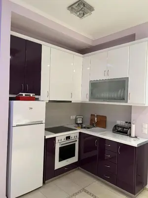 a kitchen with white appliances and purple cabinets at Piraeus Cozy Stylish, Fully Reno Apt, near metro in Piraeus