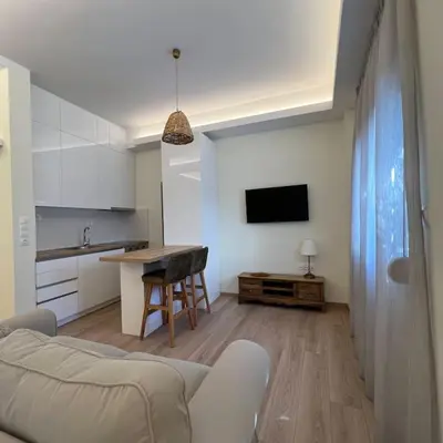a living room with a couch and a table and a kitchen at Luxury Studio “Atene” in Athens
