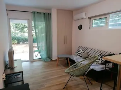 a living room with a couch and a table at Cosy and Relax Studio by the sea, with garden in Saronida