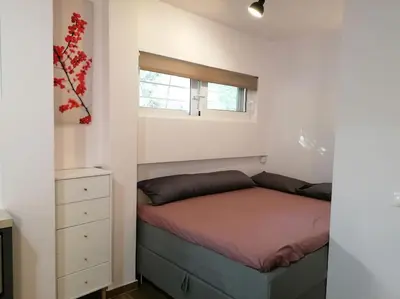 a small bedroom with a bed and a window at Cosy and Relax Studio by the sea, with garden in Saronida