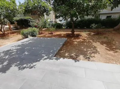 a tree in the middle of a yard with a sidewalk at Cosy and Relax Studio by the sea, with garden in Saronida