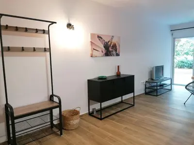 a living room with a loft bed and a desk at Cosy and Relax Studio by the sea, with garden in Saronida
