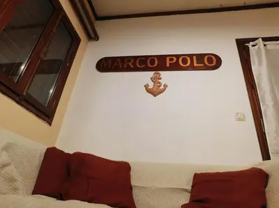 a sign on a wall above a couch in a room at Marco Polo's Mooring Cozy Navy House in Anavissos