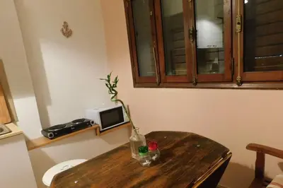 a wooden table with a vase with a flower on it at Marco Polo's Mooring Cozy Navy House in Anavissos