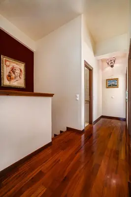 an empty living room with wooden floors and white walls at Spacious Villa with pool 500m from the beach in Vari