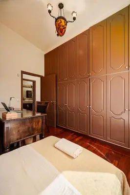 a bedroom with a bed and a desk and a desk at Spacious Villa with pool 500m from the beach in Vari