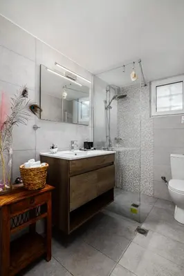 a bathroom with a sink and a toilet and a mirror at Spacious Villa with pool 500m from the beach in Vari