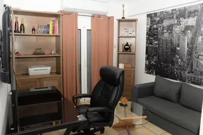 a living room with a chair and a couch at Boutique Kalithea in Athens