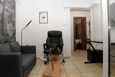 a living room with a black chair and a table at Boutique Kalithea in Athens