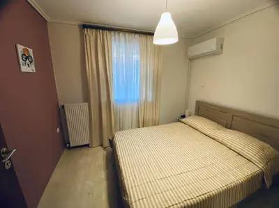 a small bedroom with a bed and a window at Near sea / Airport, Queen size bed, Fireplace in Artemida