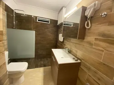 a bathroom with a toilet and a sink and a mirror at Near sea / Airport, Queen size bed, Fireplace in Artemida