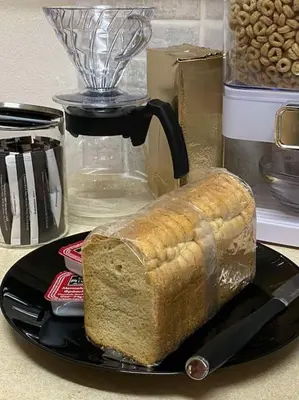 a loaf of bread on a black plate on a counter at Near sea / Airport, Queen size bed, Fireplace in Artemida