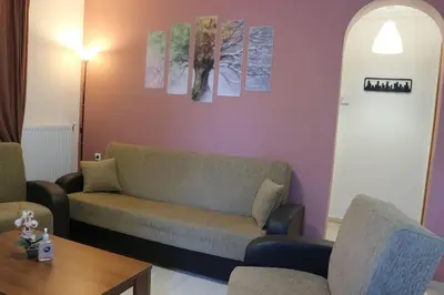 a living room with a couch and a table at Near sea / Airport, Queen size bed, Fireplace in Artemida