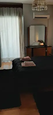 a bedroom with a black bed and a mirror at Koukaki View in Athens