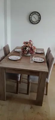 a wooden table with chairs and a clock on the wall at Koukaki View in Athens
