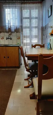 a dining room with a table and chairs and a kitchen at Koukaki View in Athens