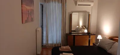 a bedroom with a bed and a dresser and a mirror at Koukaki View in Athens