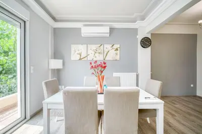 a white dining room with a white table and chairs at Charming Contemporary 2 bedroom apartment in Athens