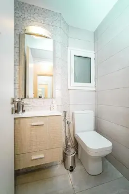 a bathroom with a toilet and a sink and a mirror at Charming Contemporary 2 bedroom apartment in Athens