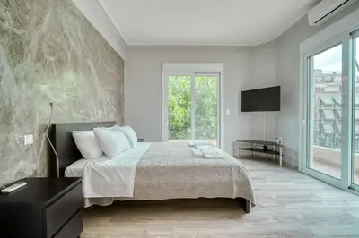 a bedroom with a bed and a large window at Charming Contemporary 2 bedroom apartment in Athens
