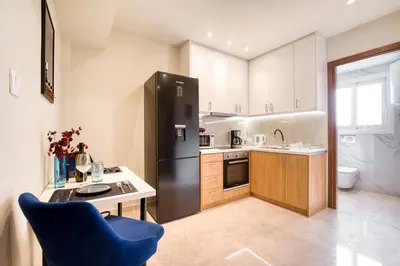 a kitchen with a black refrigerator and a blue chair at Blue Horizon - City Center Close to Metro in Athens