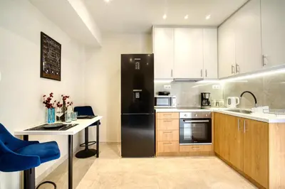 a kitchen with a black refrigerator and a table at Blue Horizon - City Center Close to Metro in Athens