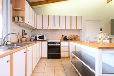 a kitchen with white cabinets and a black oven at FarmBill in Markopoulo
