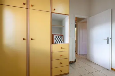 a room with a closet with yellow cabinets at FarmBill in Markopoulo