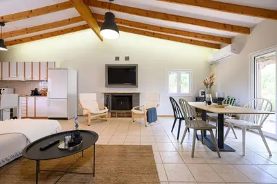 a living room with a bed and a table and chairs at FarmBill in Markopoulo
