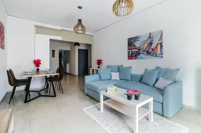 a living room with a blue couch and a table at Meandros apartment city center in Athens