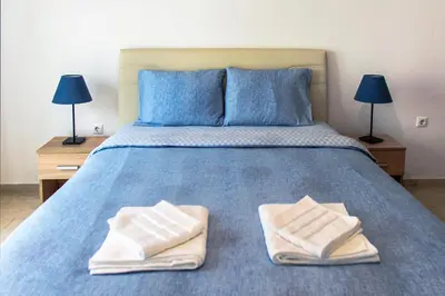 a bedroom with a blue bed with two towels on it at Meandros apartment city center in Athens