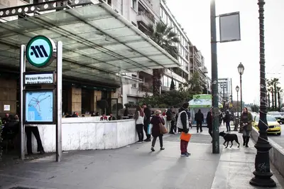 a group of people walking on a city sidewalk at Meandros apartment city center in Athens