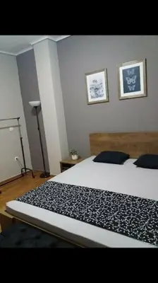 a bedroom with a bed and two pictures on the wall at Piraeus historical center in Piraeus