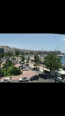 a view of a city with cars parked in a parking lot at Piraeus historical center in Piraeus