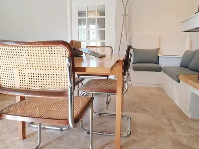 a table and chairs in a living room with a couch at Rooftop Studio Apt - 5 Min Walk to Holargos Metro in Athens
