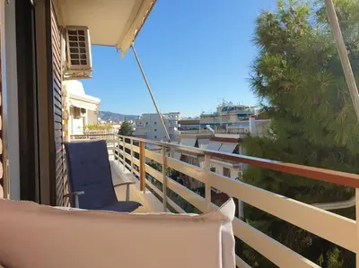 a blue chair sitting on the balcony of a building at Rooftop Studio Apt - 5 Min Walk to Holargos Metro in Athens