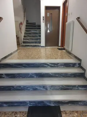 a hallway with blue and white stairs with a door at Rooftop Studio Apt - 5 Min Walk to Holargos Metro in Athens