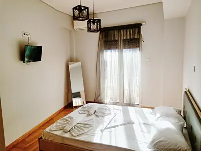 a bed in a room with a large window at Siggrou apartment in Athens