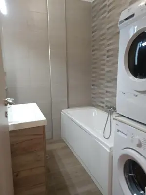 a bathroom with a washing machine and a sink at Siggrou apartment in Athens