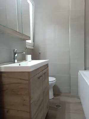 a bathroom with a sink and a toilet and a mirror at Siggrou apartment in Athens