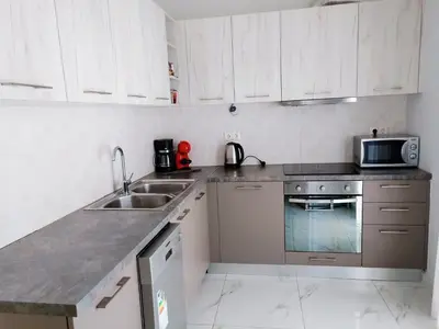 a kitchen with white cabinets and a sink and a microwave at Siggrou apartment in Athens
