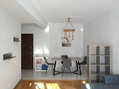 a dining room and living room with a table and chairs at Siggrou apartment in Athens