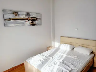 a bedroom with a bed with a painting on the wall at Siggrou apartment in Athens