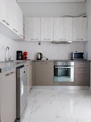 a kitchen with white cabinets and stainless steel appliances at Siggrou apartment in Athens