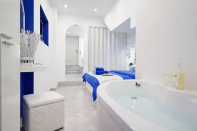 a white bathroom with a tub and two beds at Santorini Style at Nathional Archeological museum of Athens,Greece in Athens