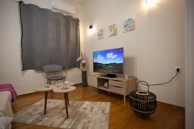 a living room with a flat screen tv on a wall at Lovely Nest Piraeus in Piraeus