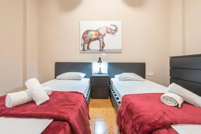 a room with two beds and a painting on the wall at Pegasus Apartment in Piraeus