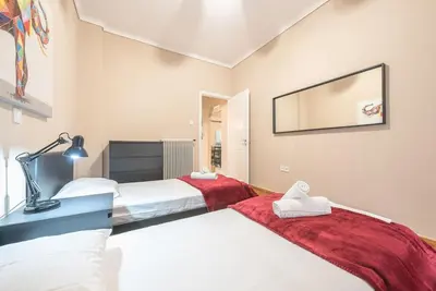 a bedroom with two beds and a lamp and a mirror at Pegasus Apartment in Piraeus