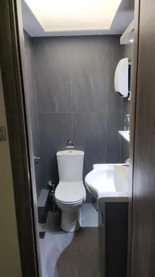 a bathroom with a white toilet and a sink at Ermou Downtown Suites by Athens Urban Retreat in Athens