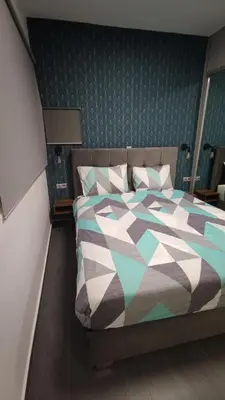 a bedroom with a bed with a colorful comforter at Ermou Downtown Suites by Athens Urban Retreat in Athens